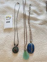 All three necklaces laid out for overview with measuring tape