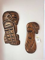 Pair of carved wood wall plaques on wall