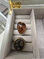 Top view of both rings showing amber cabochon and composite inlay
