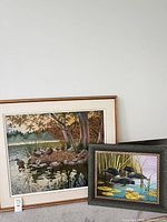 Front view of both framed paintings – larger ducks scene and smaller loons scene