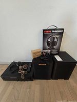 Group shot of receiver, two speakers, ION headphone box, remote, speaker wire