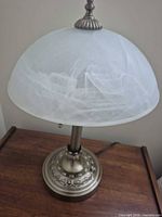 Front view of lamp showing glass shade and metal base