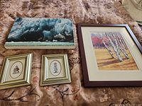 Overview of all four framed artworks laid on bed