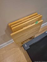 Four wood folding tables on stand, front view
