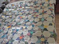 Full view of quilt covering bed showing overall pattern and colour mix