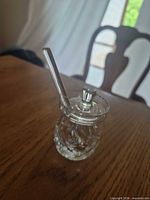 Small cut crystal jar with lid and spoon on table