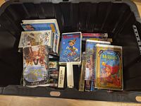 Overview of black tote filled with Disney clamshell VHS tapes; shows Jungle Book, Pinocchio, Little Mermaid cases