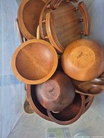 Top view of bin showing multiple wooden bowls, tray and utensils