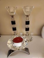 Pair of crystal candlesticks and crystal tealight holder with red tealight displayed