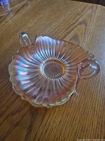 Top view of iridescent marigold carnival glass candy dish showing ribbed pattern and handles