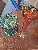 Marigold vase and green lidded candy dish on table