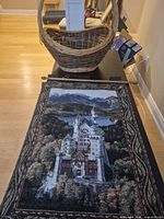 Tapestry laid out on table with wicker basket behind