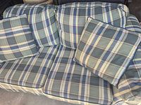 Overall view of plaid sofa showing seat and back cushions and throw pillows