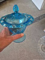 blue pressed glass covered dish held in hand