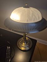 Lamp lit showing glass shade and metal rim