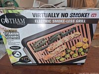 Front of boxed Gotham Steel Electric Smoke-Less Grill showing product and branding