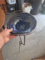 Full view of blue glass basin held above metal stand
