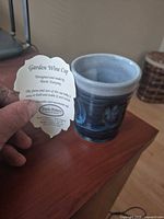 Cup with maker’s tag showing name, size reference
