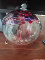 Front view of clear glass friendship ball with multicolour inclusions
