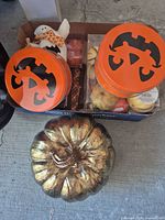 Box containing tins, boxed gourds, ghost figure and gold pumpkin
