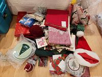 pile of linens, plates, soap dispenser, Santa hat and misc items