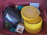 Overview of bin showing salad spinner, electric appliance, ice cube trays, mixer and boxed grater