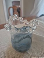 Full view of vase showing blue/white swirl body and ruffled clear rim