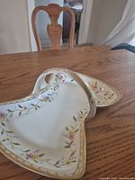 Oblique view of entire porcelain tray showing floral border, shape, and handle