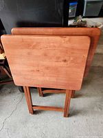 Front view of both folding wooden TV tray tables standing upright