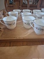 Eight Pasadena pattern teacups on tray, showing floral design and platinum rim