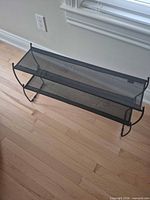 Full view of black metal two-tier mesh shoe rack