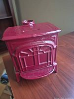 Front view of red cast iron coin bank