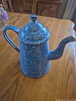 Full view of blue speckled enamel coffee pot on table
