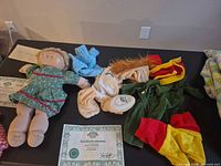 Full lot showing doll, certificate, and assorted outfits