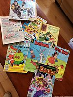 Lot overview showing sticker album and seven comics spread on table