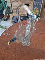 Glass basket holder with several bird-topped stirrers inside
