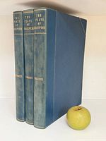 All three volumes standing with apple for scale