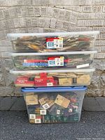 three stacked clear bins filled with packaged loofahs and bags