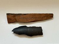 Oak hull fragment and metal shrapnel side by side