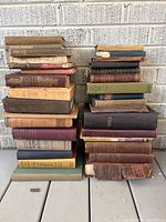 Two stacks of vintage hardcover books showing spines and wear