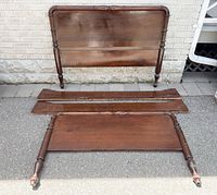 Full view of headboard, footboard and both side rails laid out on pavement