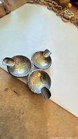 Top view showing three coin bowls with cigarette rests