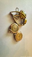 Front view of three watches and ladies case with chain