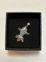 Front view of silver fish pendant in box