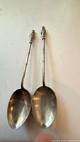 Two small silver spoons with figural finials
