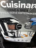 Front of boxed Cuisinart Grind & Brew coffeemaker showing product image and branding