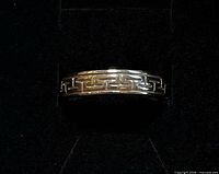Close view of front of silver band with Greek key pattern