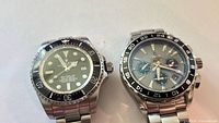 Front view of both watches showing dials, bezels and bracelets