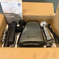 open box view showing grinder, auger, grinding head, pusher, manual