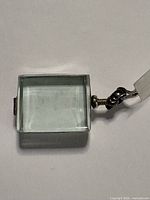 Front view of rectangular glass locket showing clear face and screw bail
